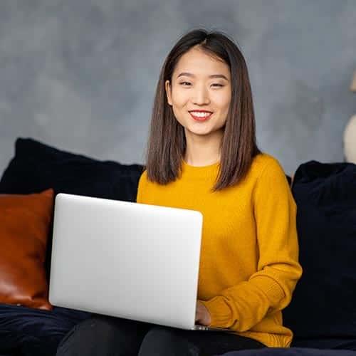 asian business woman working in laptop on sofa jap GM7YU66 copy